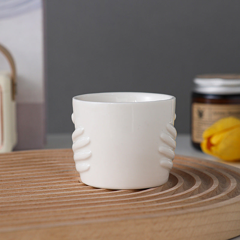 Bougie ERMITUS crème vanillée en céramique blanche posée sur une table